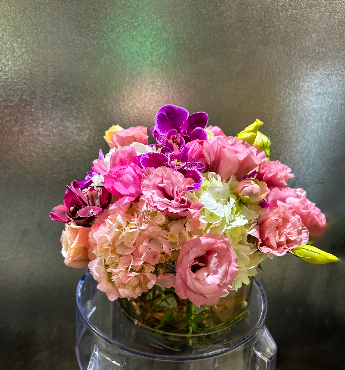 Elegant pink and white floral arrangement with vibrant purple orchids in a clear vase, showcasing delicate blooms perfect for a sophisticated Houston event. Designed by VIP Floristry for luxury occasions.