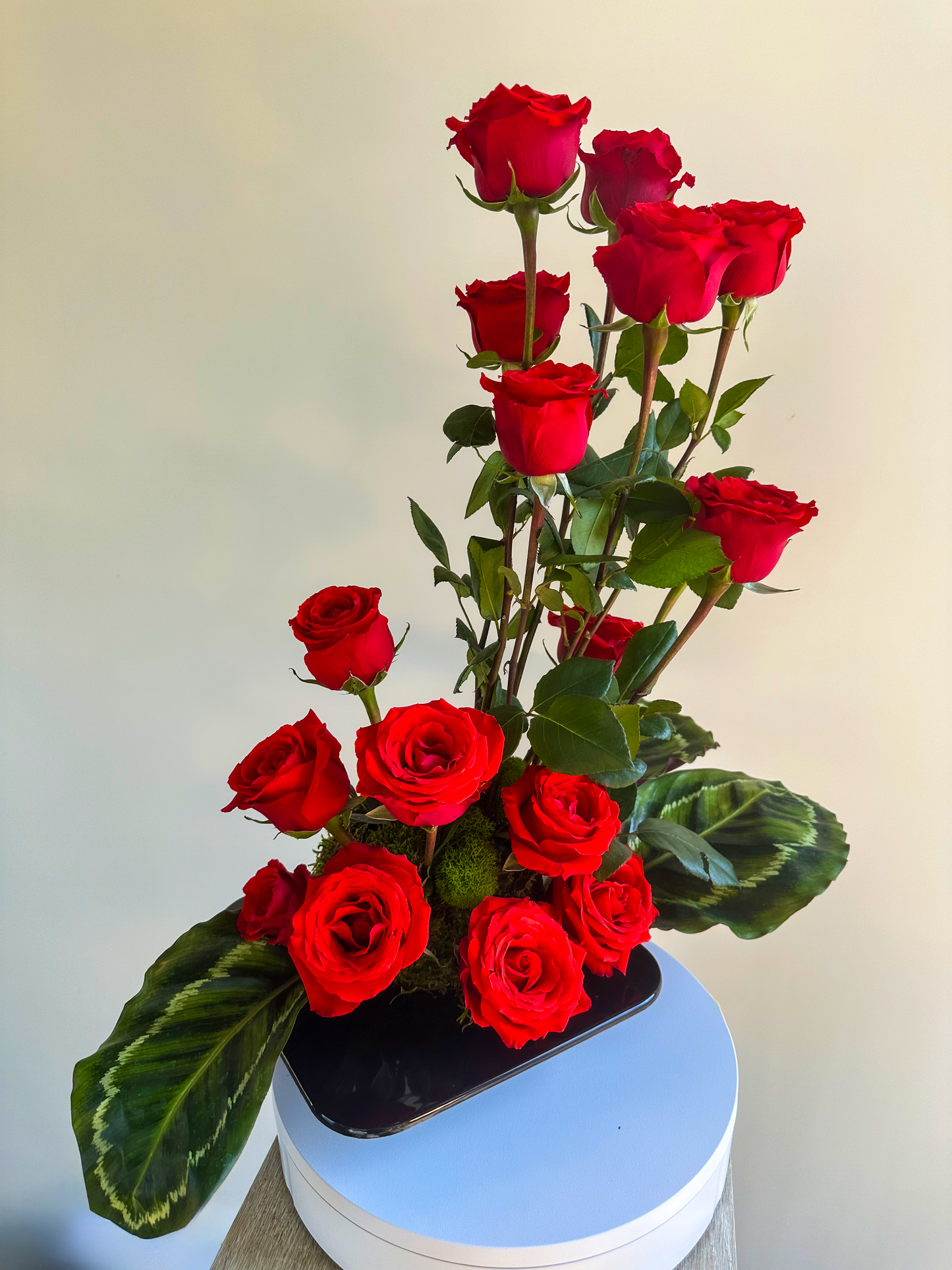 Luxurious bouquet of red roses in a contemporary black vase, accented with deep green leaves. Perfect for creating an elegant ambiance, this floral display exemplifies VIP Floristry’s expertise in premium flower arrangements for Houston events and decor.