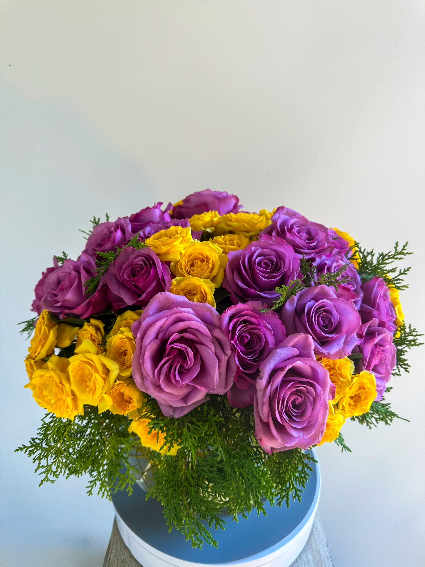 Side angle of the lavender and yellow rose arrangement, featuring premium roses and lush greenery in a glass bowl, crafted for a modern yet classic look for Houston's luxury floral scene.