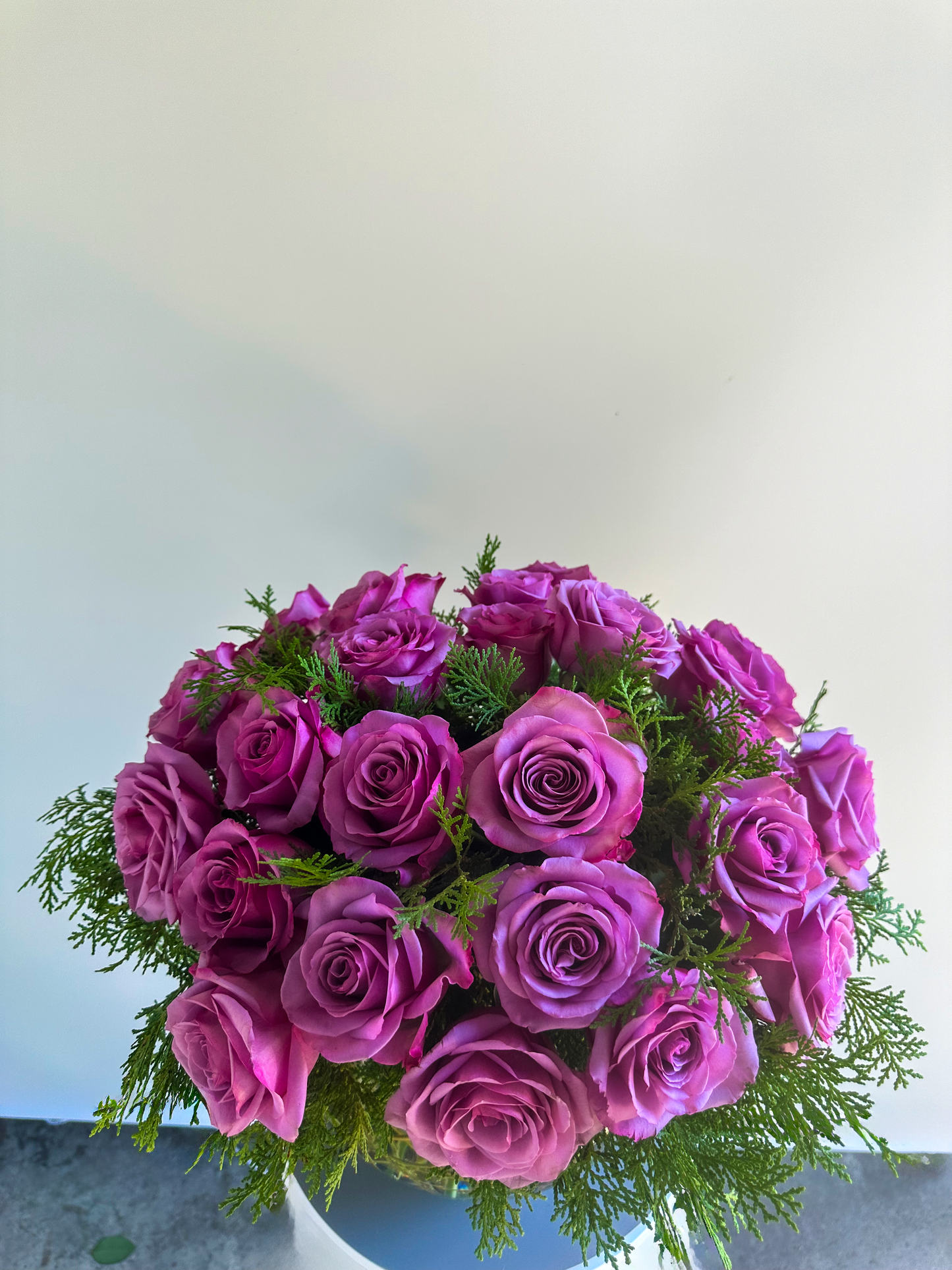 Lavender rose arrangement with lush greenery in a clear vase, crafted by VIP Floristry for luxury floral arrangements in Houston.