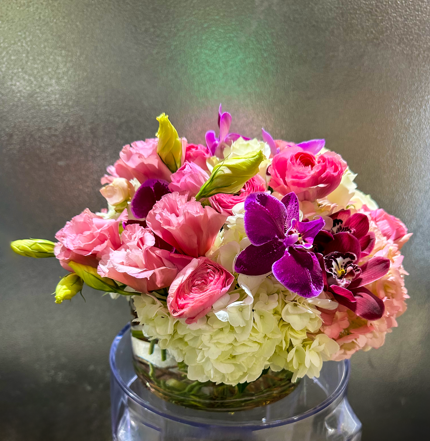 Exquisite pink and white flower arrangement with striking purple orchids, elegantly displayed in a clear vase. Perfect for luxury events in Houston, crafted by VIP Floristry for an elegant ambiance.