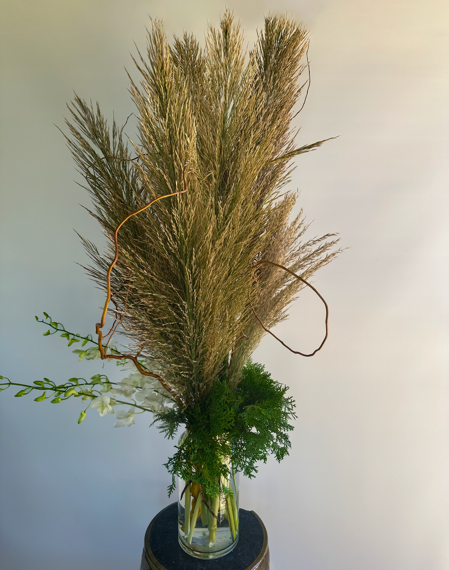 Sophisticated Houston floral design with lavender roses, pink proteas, pampas grass, and white orchids in a tall vase – ideal for a refined, rustic look.