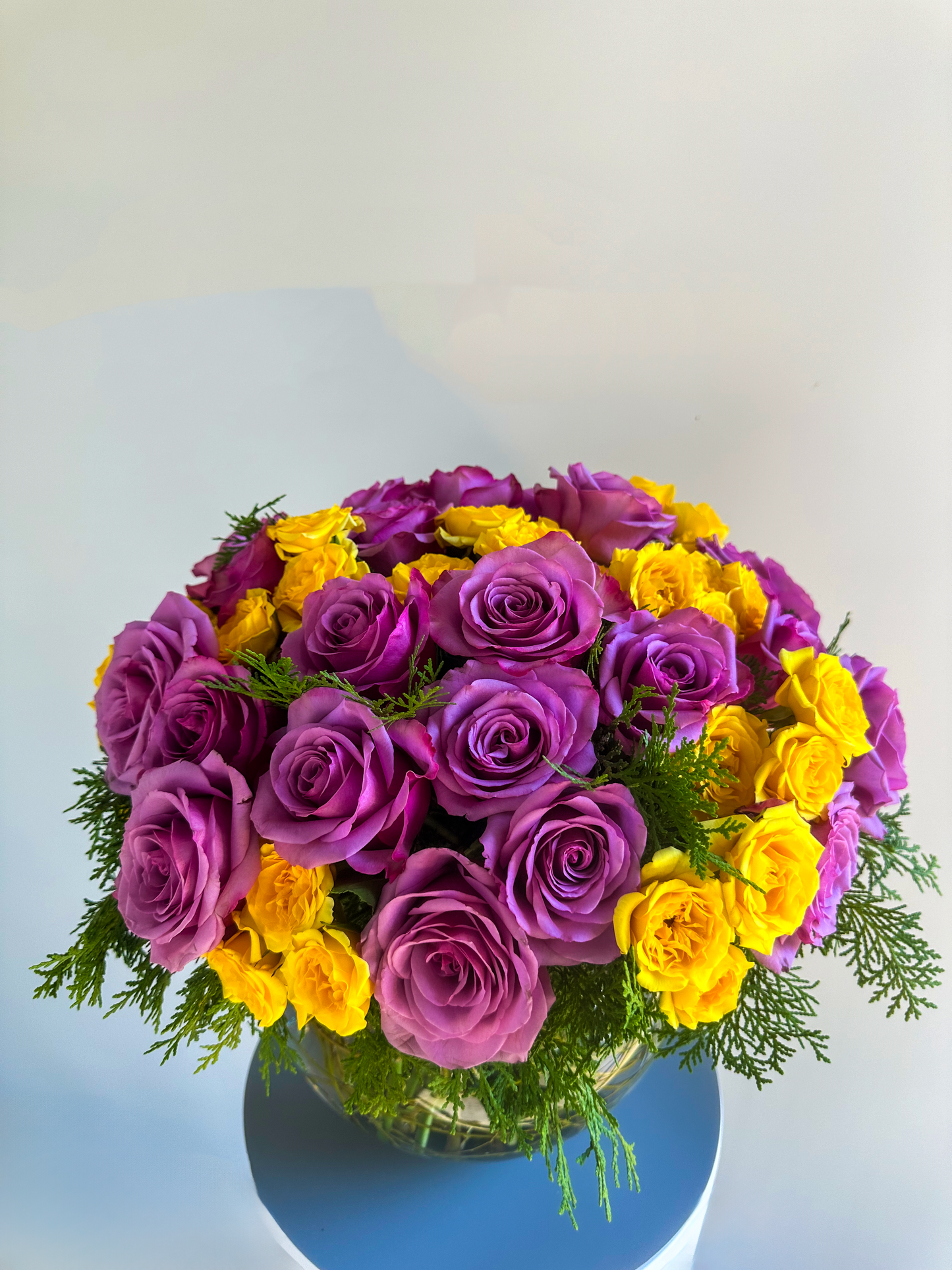 Close-up of a bowl arrangement showcasing lavender and yellow roses, carefully arranged with fresh greenery for a sophisticated look, ideal for upscale Houston floral decor.