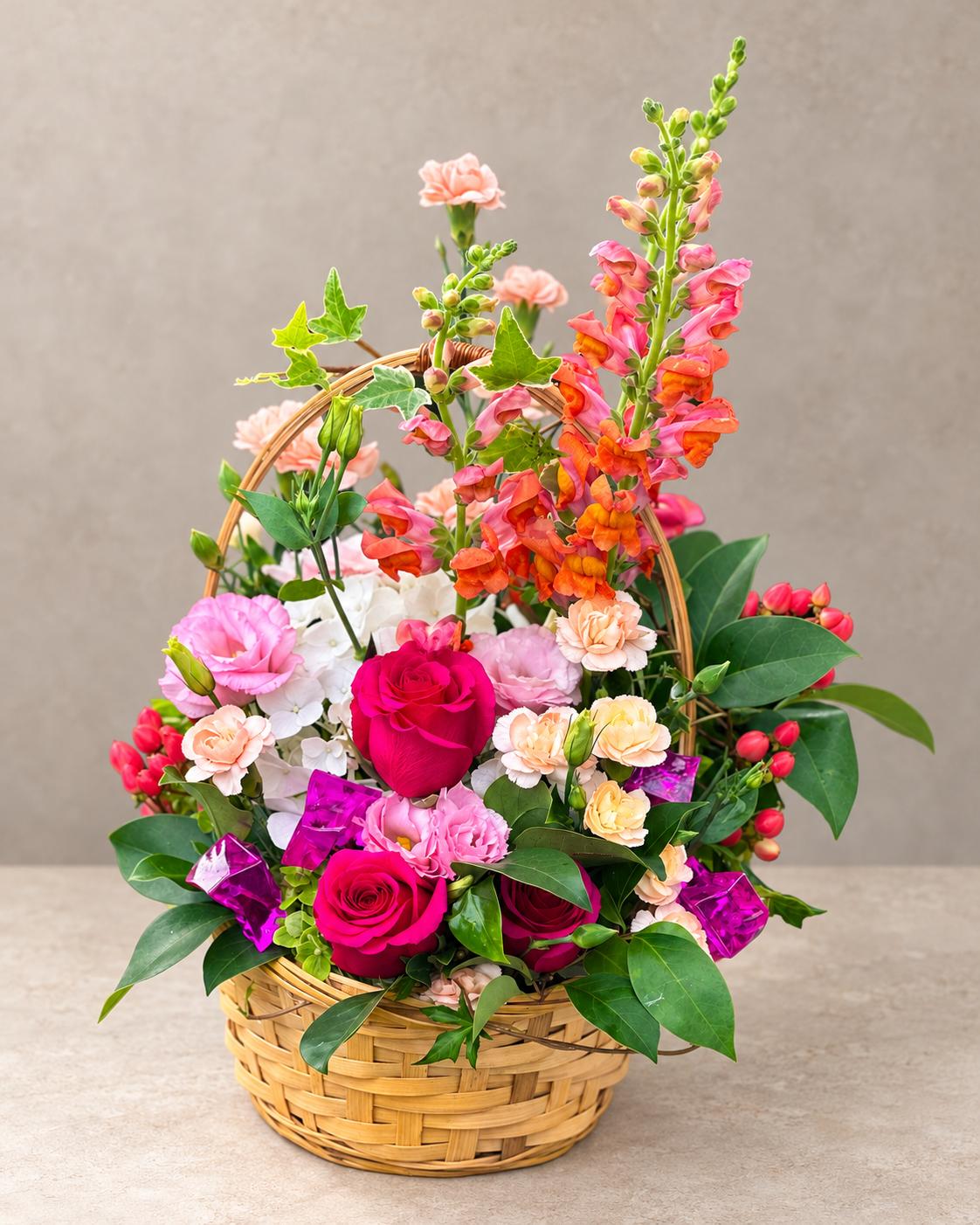 Sweet Girl basket arrangement with coral snapdragons, hot-pink roses, pink lisianthus, white hydrangea and magenta accents.