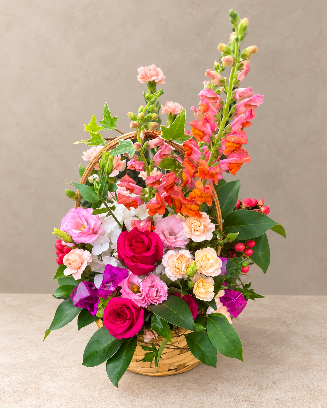 Closer view of the Sweet Girl floral basket with coral snapdragons, fuchsia roses, peach carnations, hydrangea and pink berries.