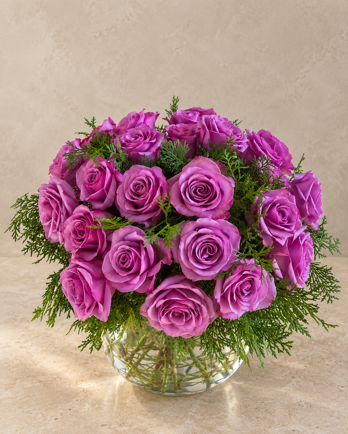 A vibrant bouquet of magenta-purple roses arranged in a clear glass vase with green foliage, set against a neutral beige textured background.