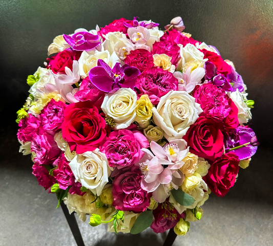 Top view of a lavish arrangement featuring pink, red, and white roses, orchids, and greenery, designed to add elegance and sophistication to celebrations, crafted by VIP Floristry, Houston's premier floral studio.