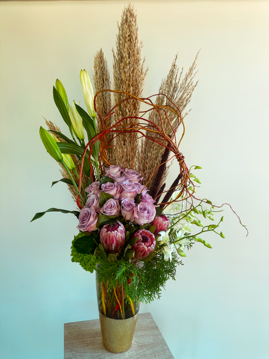 Houston-inspired floral arrangement with pampas grass, lush greenery, and white dendrobium orchids in a tall vase – perfect for natural elegance.